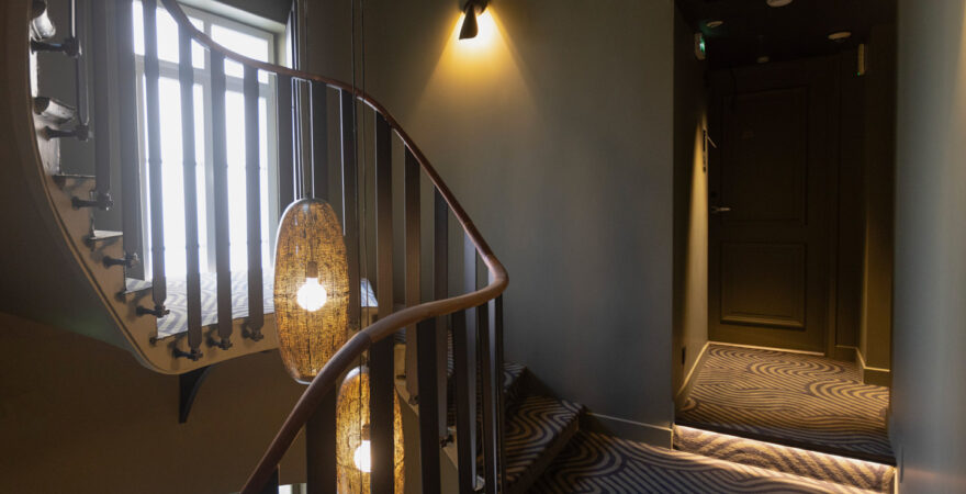 Access to the rooms via a refined staircase at Hôtel Les Coulisses du Théâtre, ideal for day-use stays in Saint-Quentin
