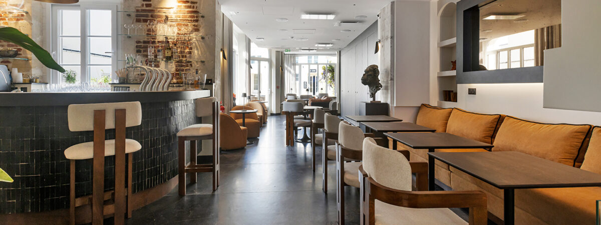 Gemütlicher Bereich mit Sitzgelegenheiten im Hôtel Les Coulisses du Théâtre in Saint-Quentin, ideal, um einen Snack, ein Glas Wein, ein Bier oder einen Cocktail zu genießen