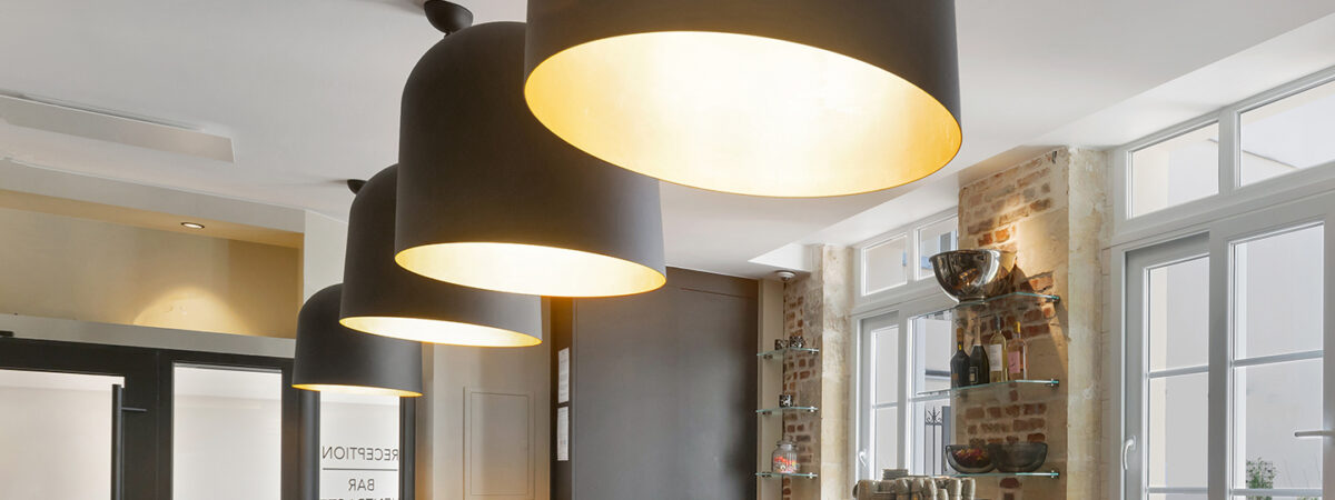 Warme Atmosphäre an der Bar des Hôtel Les Coulisses du Théâtre in Saint-Quentin, mit bequemen Sitzgelegenheiten, Premium-Service und elegantem Ambiente