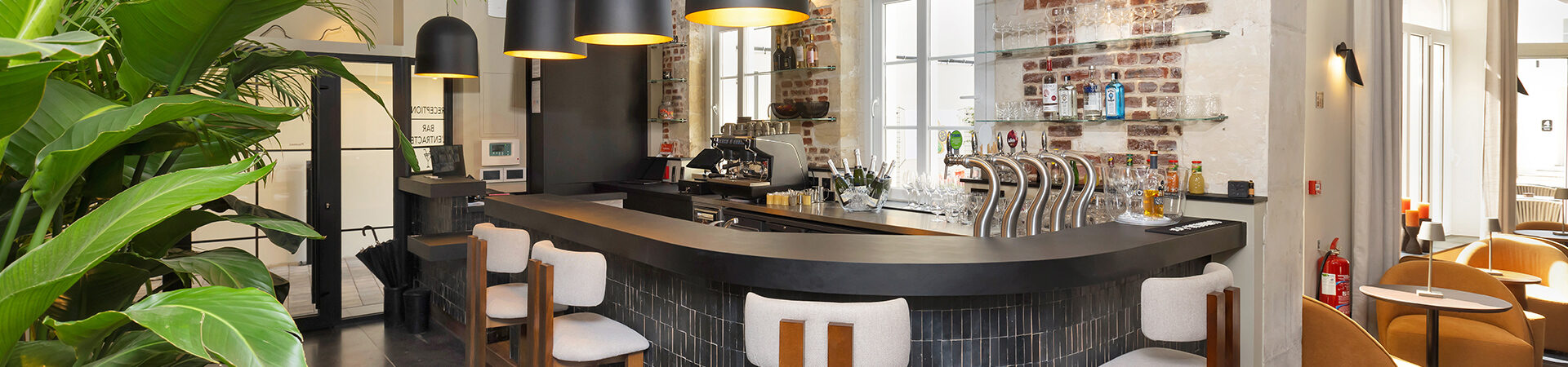 Espace chaleureux avec assises à l’Hôtel Les Coulisses du Théâtre à Saint-Quentin, idéal pour savourer un snack, un verre de vin, une bière ou un cocktail