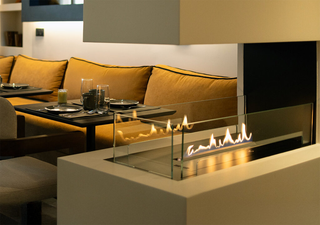 Ambiance cosy autour de la cheminée de l’hôtel, parfaite pour un moment de détente