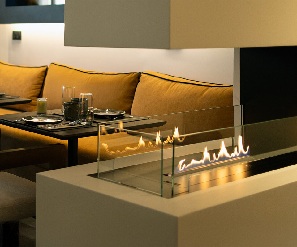 Ambiance cosy autour de la cheminée de l’hôtel, parfaite pour un moment de détente