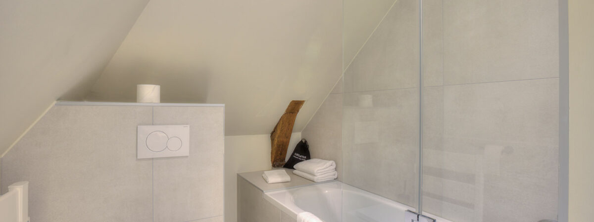 Modernes Badezimmer mit Badewanne und Dusche im Hotelstudio